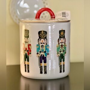 AUDREY’S#7PT1764, NWT, WHITE CERAMIC NUTCRACKER CANISTER WITH A RED HANDLE.
